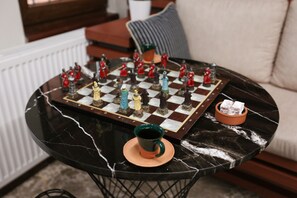 A chessboard on a marble table with a cup and a small dish of sweets. - Xenia Hotel Istanbul (Istanbul)