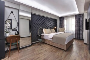 A modern bedroom with a bed, bedside table, lamp, and a decorative mirror. - Xenia Hotel Istanbul (Istanbul)