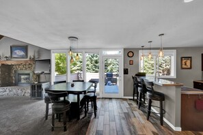 Una cocina amplia con zona de comedor, ventanas grandes y chimenea de piedra.