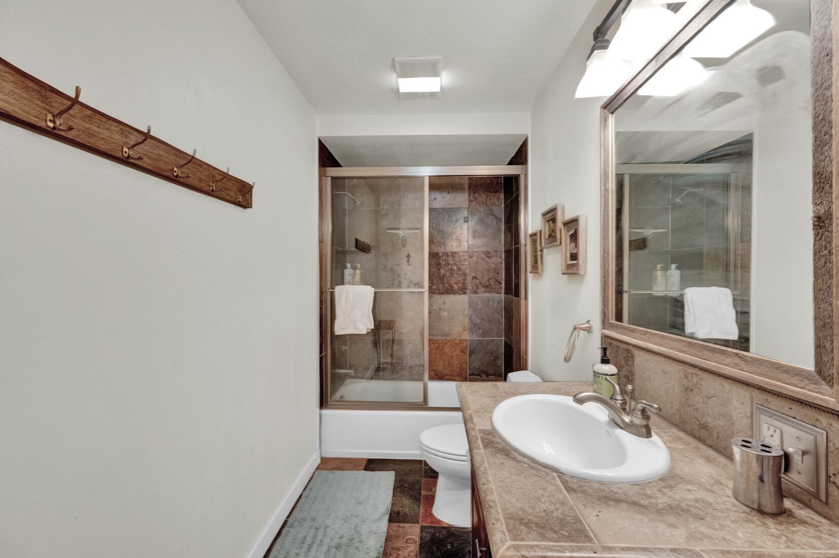 A modern bathroom with a large mirror, a bathtub, and a sink.