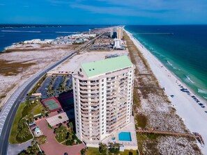 Un hôtel de grande hauteur doté de nombreux balcons, d’une piscine et offrant une vue sur la plage.