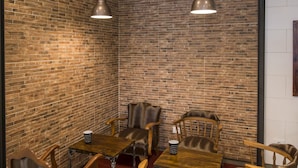 A room with brick walls, wooden furniture, and pendant lighting. - Hotel Mino (Ourense)