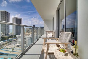 A balcony with a city view, wooden furniture, and a bottle of wine. - Upscale Condo w/ Pool Access in Hyde Beach House! (Hollywood)