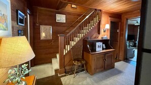 A wooden interior with a staircase, a desk, and a chair. - Historic cottage just minutes from downtown Harbor Springs! (Harbor Springs)