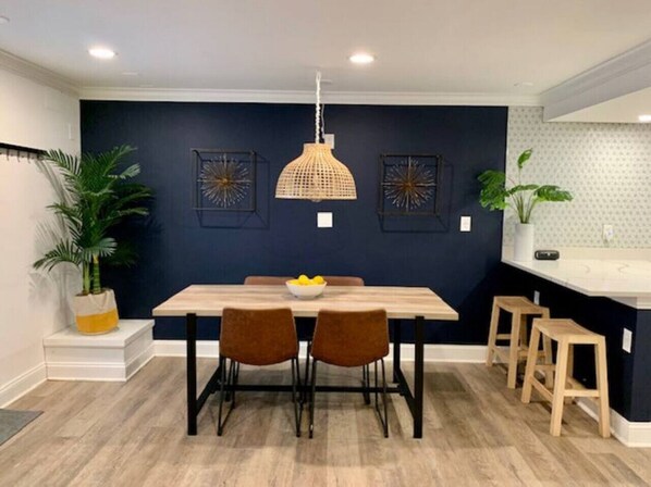 A dining area with a table, chairs, a hanging light fixture, and wall art. - Deluxe Basement Guest Suite w/ Luxury Amenities Minutes From BWI/Annapolis/DC (Odenton)