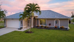 Einbungalow mit Garage, überdachter Veranda und gepflegtem Rasen.