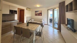 A modern apartment with a kitchen, dining area, living room, and balcony. - Holiday apartment with balcony and air conditioning (Lignano)