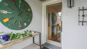 A room with a green clock, a wooden bench, and a door leading to another room. - The Hideaway Suite: Sauna & Lux Amenities (Staunton)