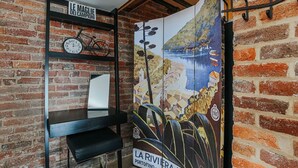 A brick wall with a shelf holding a bicycle, a clock, and a sign reading "LE MAGLIE DEI CAMPIONI". - The Hideaway Suite: Sauna & Lux Amenities (Staunton)