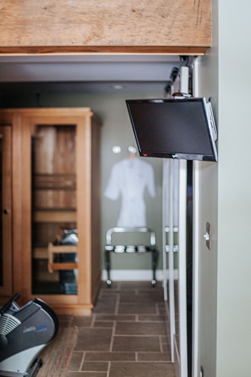 Une pièce équipée d’un tapis de course, d’une armoire en bois et d’un miroir.