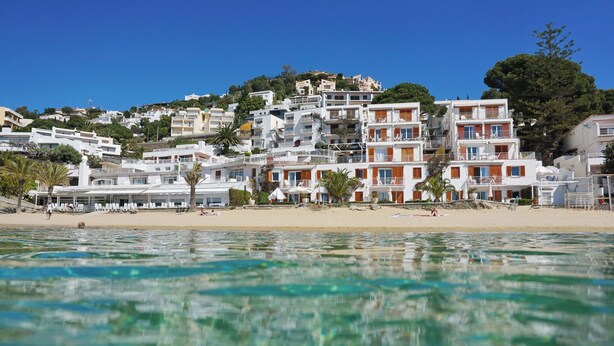 A coastal town with buildings on a hillside, a sandy beach, and clear blue water. - Holiday apartment with pool (Roses)