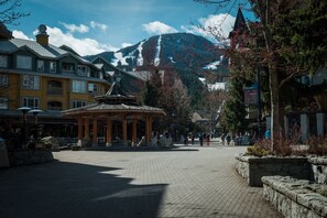 Ein Platz mit einem Pavillon, Gebäuden und einem Berg im Hintergrund.