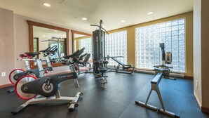 A gym with cardio equipment, weight machines, and a mirror.