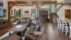A spacious living area with a wooden ceiling, a dining table, and a sofa set. - Luxury Family Waterfront Home | Dock + SUP/Kayak (Sagle)
