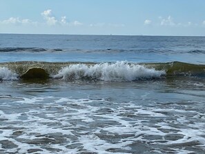 A beach with waves crashing onto the shore.
