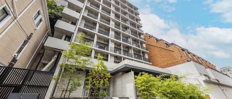 A multi-story building with a modern architectural design, featuring a central staircase and a series of balconies.