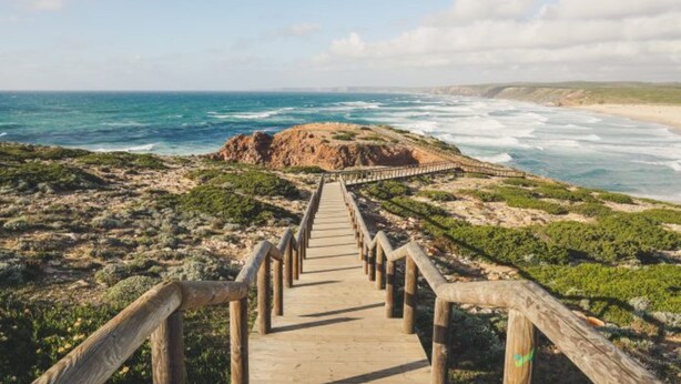 A wooden boardwalk leading to a rocky coastline with ocean views. - 5 Star Villa Hibiscus - Quinta Verde Retreat (Algarve)