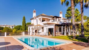 A large, white villa with a swimming pool, a patio, and a well-maintained garden. - 5 Star Villa Hibiscus - Quinta Verde Retreat (Algarve)
