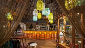 An indoor bar area with wooden flooring, a bar counter, and hanging decorative lanterns. - Vidanta Mayan Palace 2 BR 2 BA Suite With Kitchen Sleeps 8 - Cancun Riviera Maya (Carmen Carretera Federal)