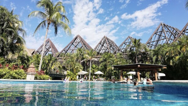 A pool area with palm trees and a clear blue sky. - Vidanta Mayan Palace 2 BR 2 BA Suite With Kitchen Sleeps 8 - Cancun Riviera Maya (Carmen Carretera Federal)