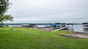 Moored boats line the lakeside dock, surrounded by a lush grassy area.