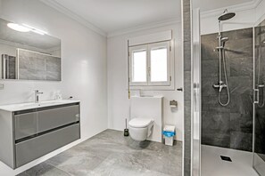 Un baño moderno con ducha, inodoro y lavabo.