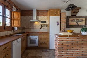 Eine kleine Küche mit Holzausstattung, einer Mikrowelle, einem Kühlschrank und einem Spülbecken.