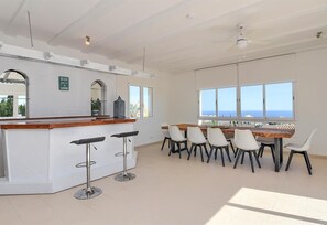 Eine geräumige Küche mit Bar, großen Fenstern und Meerblick.