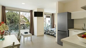 A modern apartment with a kitchen, dining area, and a balcony with a view of the city. - Apartment Albamar 1D with Mountain View, Wi-Fi, A/C & Balcony (Puerto de Mogán)