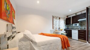 A bedroom with a bed, an orange throw blanket, a white pillow, and a painting on the wall. - Vacation Home 'El Lagar' with Mountain View, Shared Terrace and Wi-Fi (Los Silos)