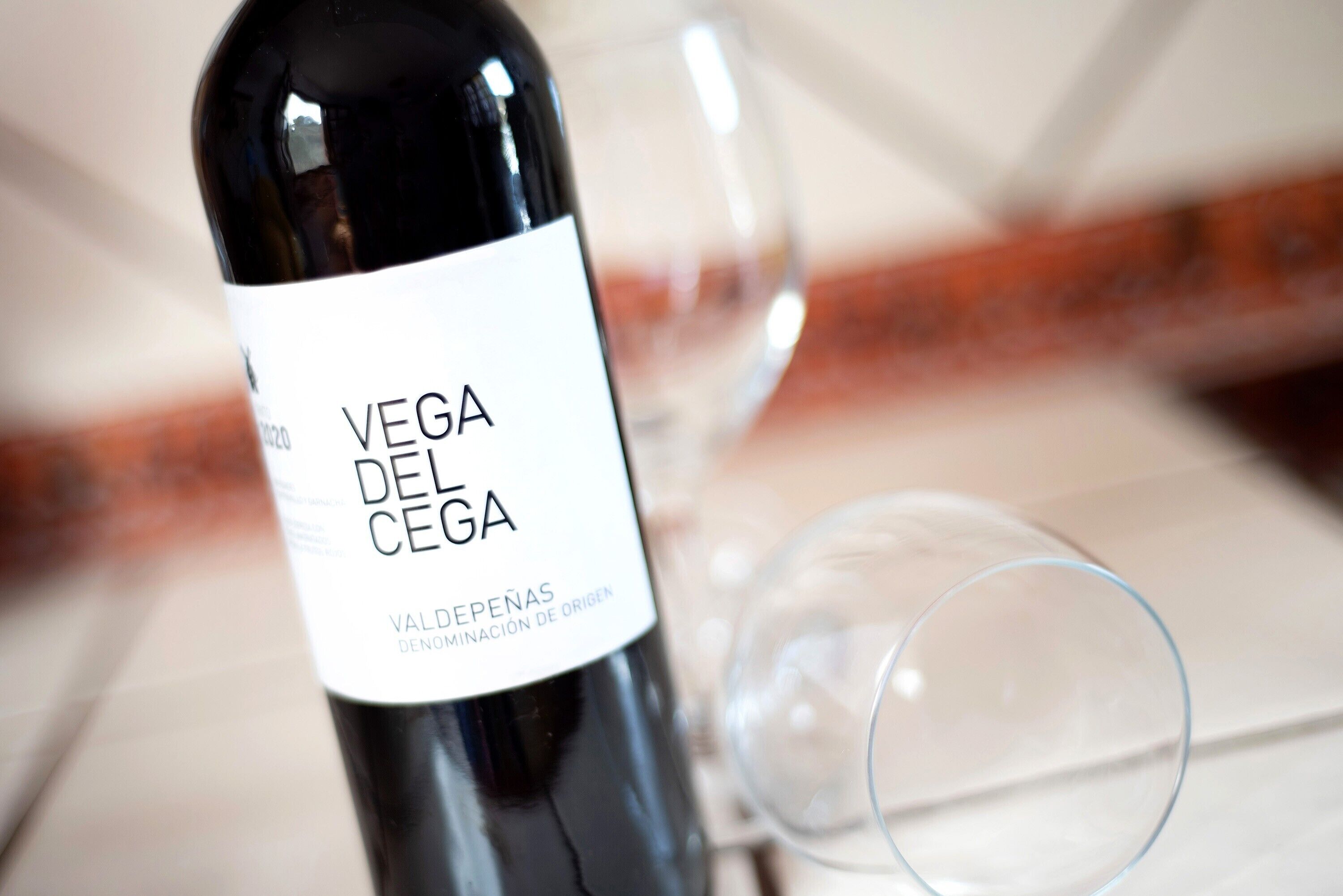 Een fles Vega del Cea wijn met een etiket, en een wijnglas ernaast.