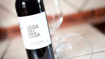 Een fles Vega del Cea wijn met een etiket, en een wijnglas ernaast.