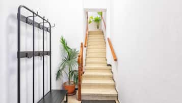 Een trap met een houten leuning en een metalen poort aan de linkerkant.