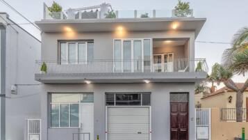 Een woonhuis met twee verdiepingen, een balkon, grote ramen en een garage.