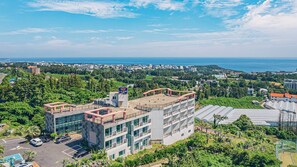 A modern hotel with multiple floors, a rooftop terrace, and a view of the sea. - J View Hotel (Seogwipo)