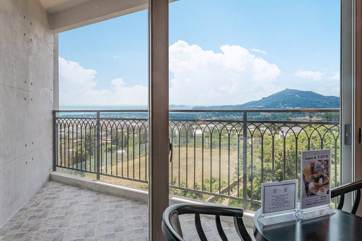 Een balkon met uitzicht op een berg en een verre skyline.