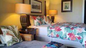 A hotel room with a bed, a sofa, two bedside lamps, and a wall with two framed pictures. - KAUA'I BEACH RESORT-BEACHFRONT, OCEAN VIEW, POOLSIDE VIEW FROM YOUR LANAI (Lihue)