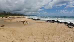 A beach with a sandy shore, waves, and a partly cloudy sky. - KAUA'I BEACH RESORT-BEACHFRONT, OCEAN VIEW, POOLSIDE VIEW FROM YOUR LANAI (Lihue)
