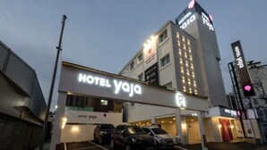 A hotel with a prominent sign reading "HOTEL YOJA" and a parking area with several cars. - Hotel Yaja Gwangalli (Busan)