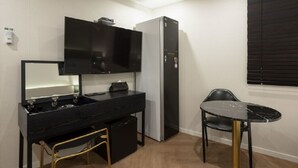 A compact room with a black countertop sink, a mirror, a black refrigerator, and a small table with a chair. - Hotel Yaja Gwangalli (Busan)