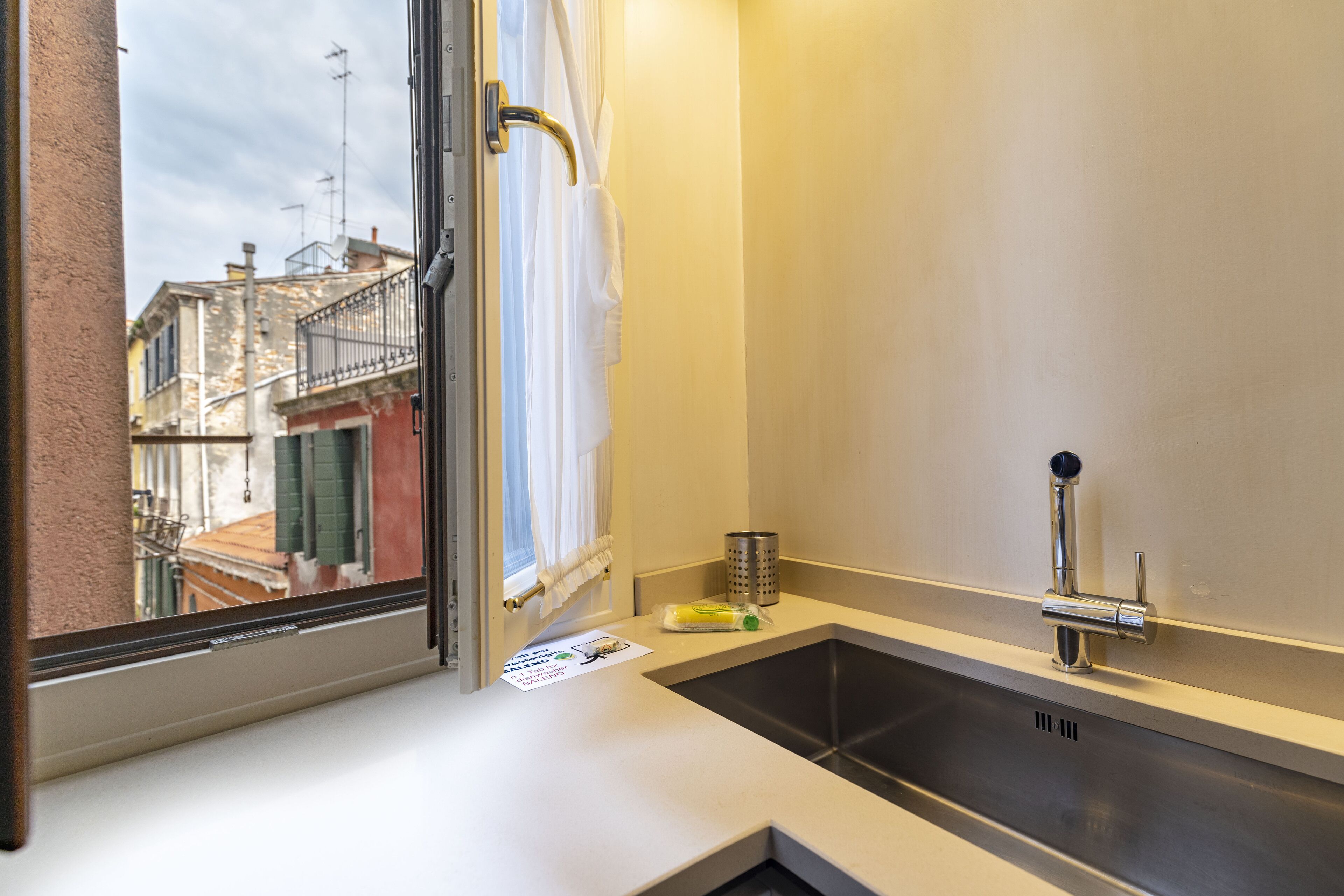 A bathroom with a window, a sink, and a towel rack.