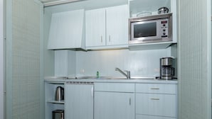 Una cocina compacta con microondas, cafetera y tostadora.