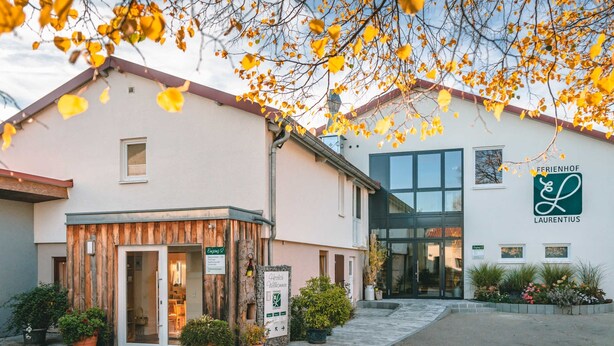 Un edificio con fachada de madera, entrada de vidrio y señalización que dice 'FERRIENFÖHR LAURENTIUS'.