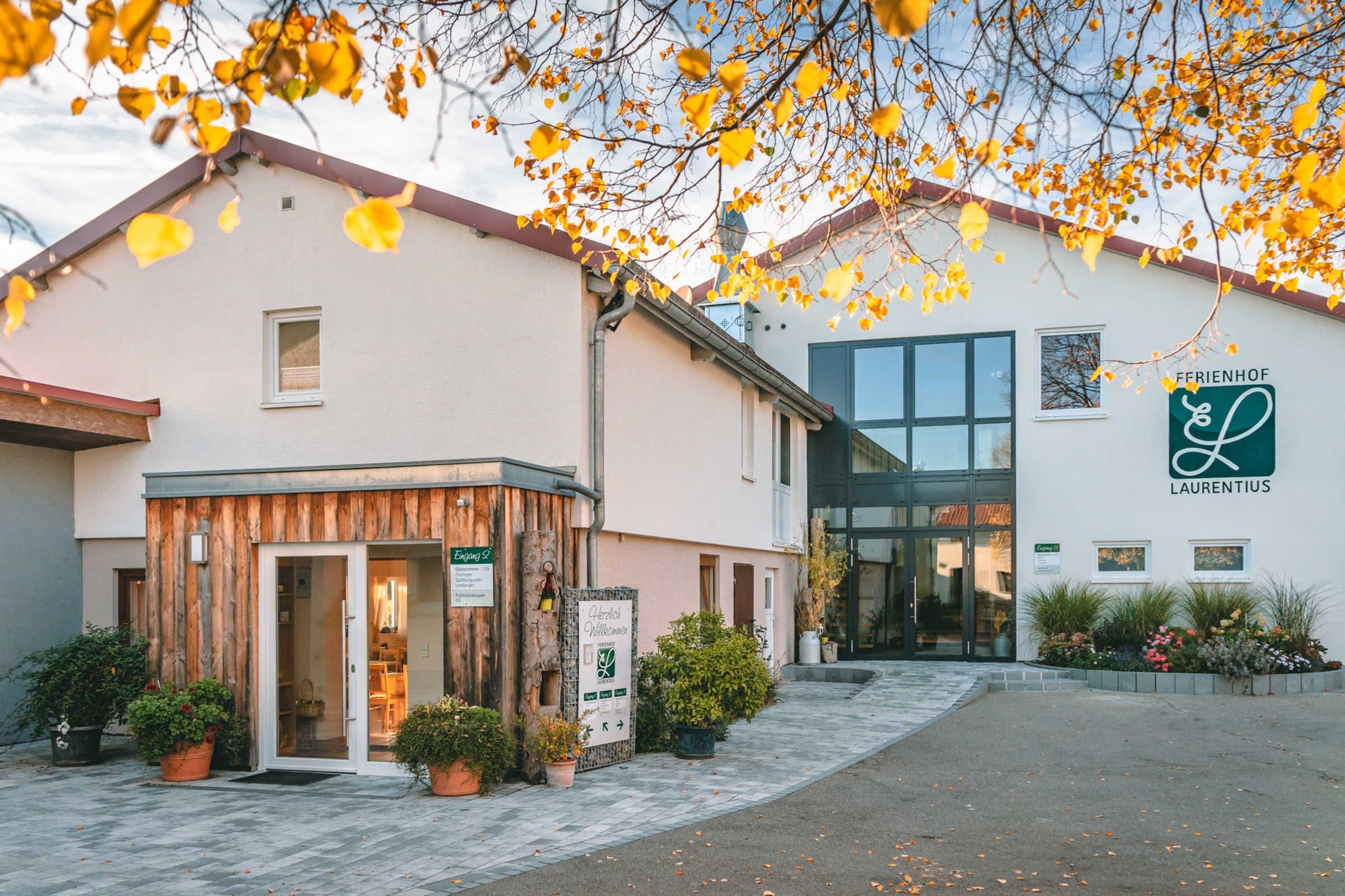 Ein Gebäude mit Holzfassade, Glastür und Beschilderung für 'FERRIENFÖHR LAURENTIUS'.