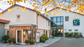 Ein Gebäude mit Holzfassade, Glastür und Beschilderung für 'FERRIENFÖHR LAURENTIUS'.