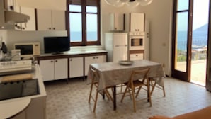 Une cuisine équipée d’une table et de chaises, d’un téléviseur et de placards.