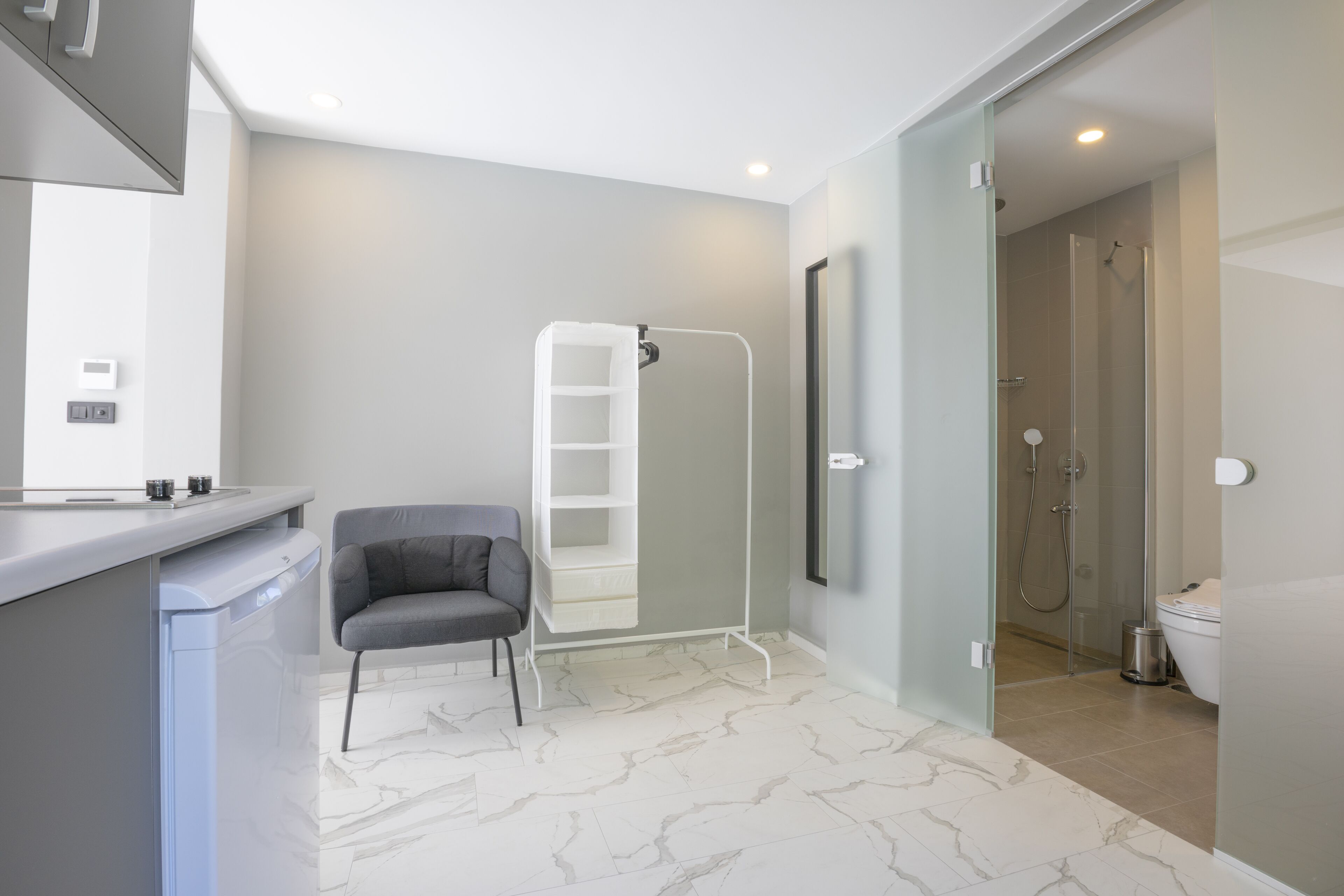 Une salle de bain moderne équipée d’une douche, de toilettes et d’une chaise.