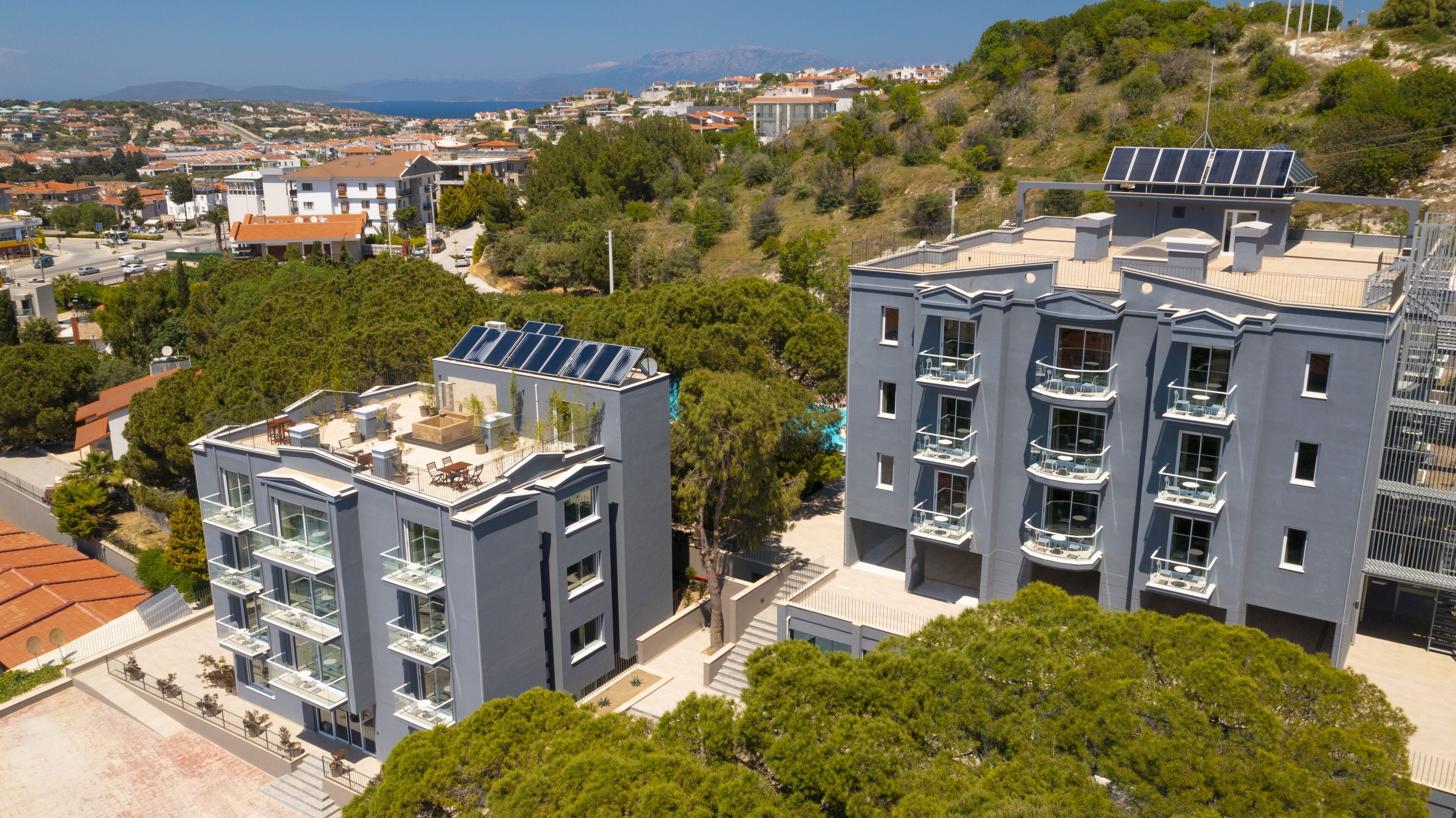 A modern building with multiple balconies and solar panels on the roof.