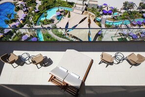 Un espace piscine aménagé sur le toit, avec des chaises longues et des parasols.