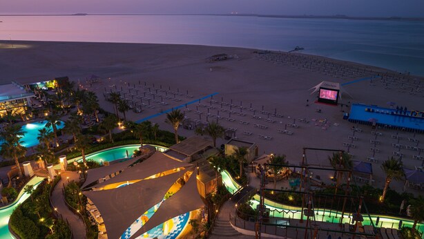 A resort with multiple swimming pools, a beach area with sun loungers, and a large building with a pool. - Centara Mirage Beach Resort Dubai (Dubai)